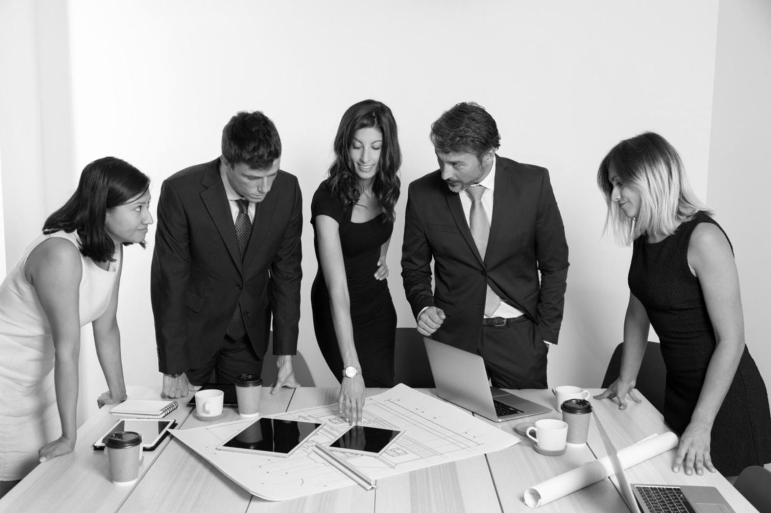 Session de travail collaborative sur l'analyse d'investissement avec ordinateurs et documentation financière